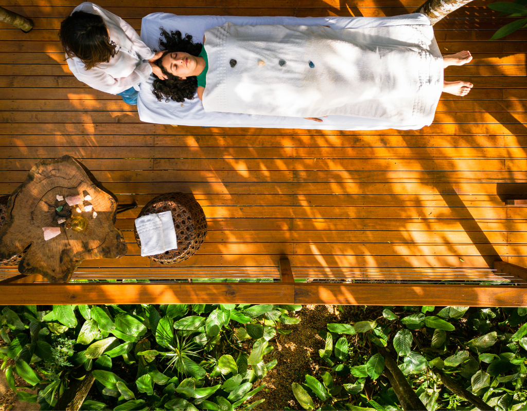 Woman receiving energy healing on a massage table during trauma release work.